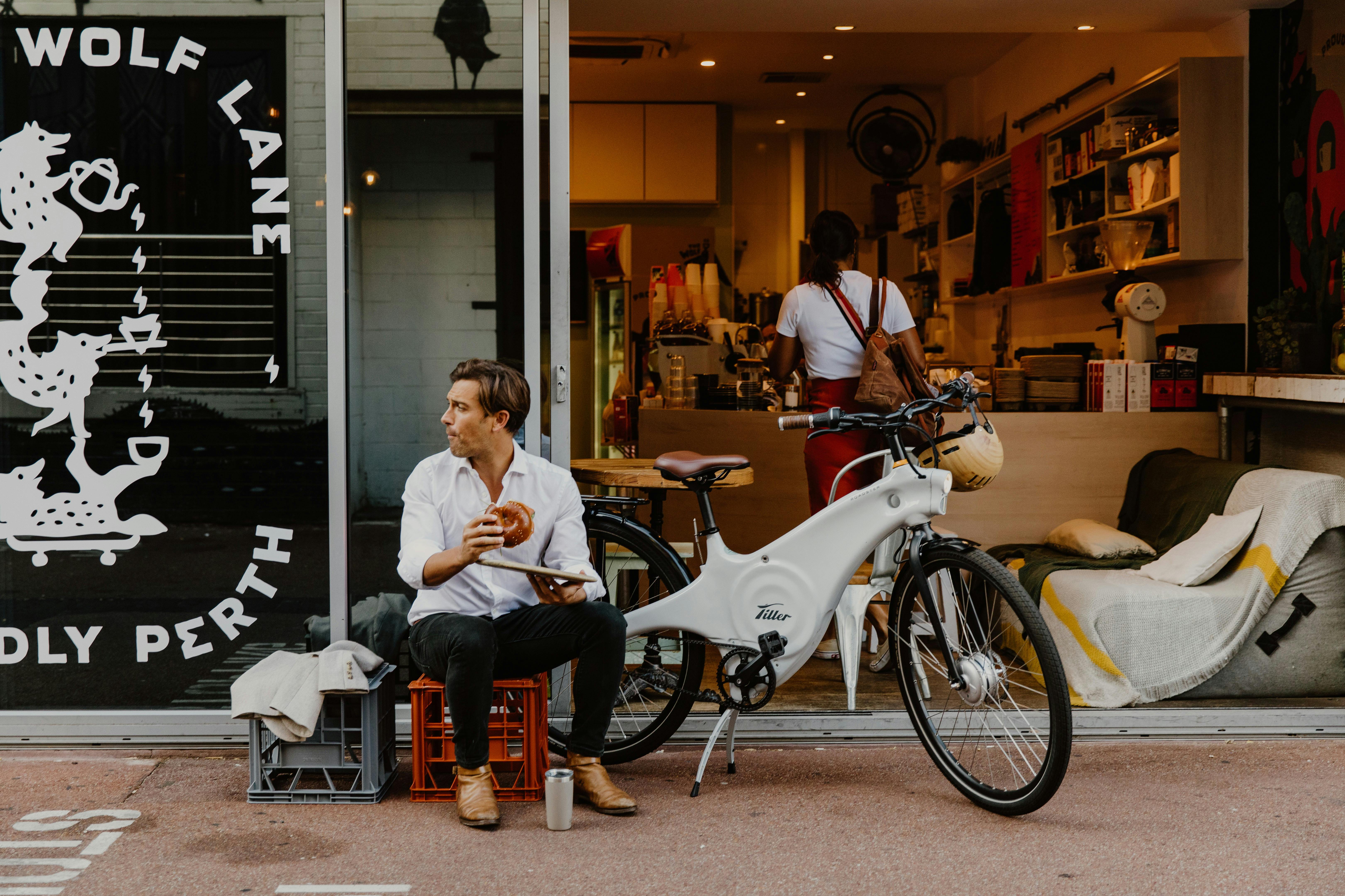 Man sitting next to a hire bike