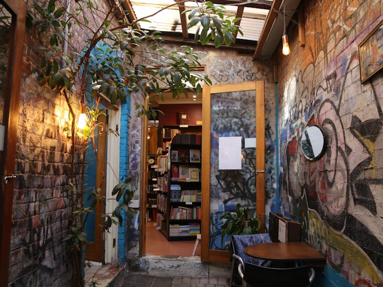 A photo of the side passage into the bookstore, colourful graffiti covering the walls