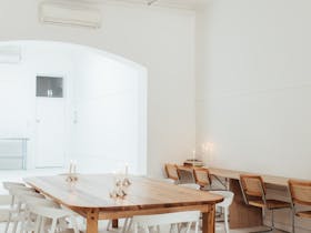 Light filled commercial space, with a large wooden table in the centre.