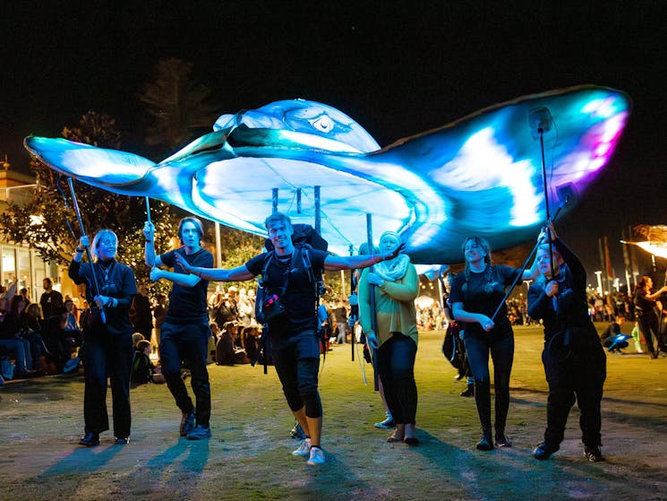 A giant light up sting ray with 6 puppeteers underneath controlling it