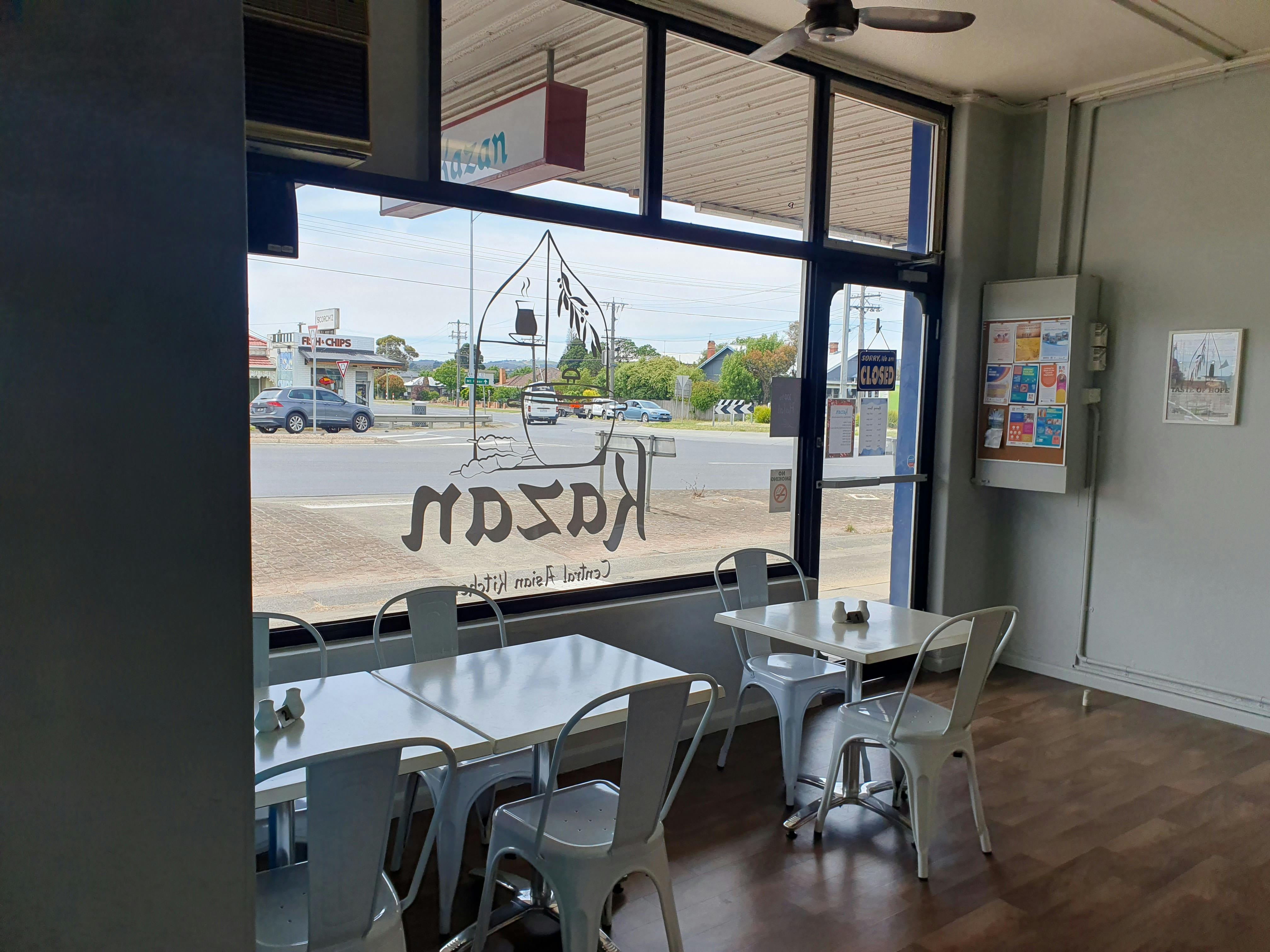 Entrance showing signage and couple of tables