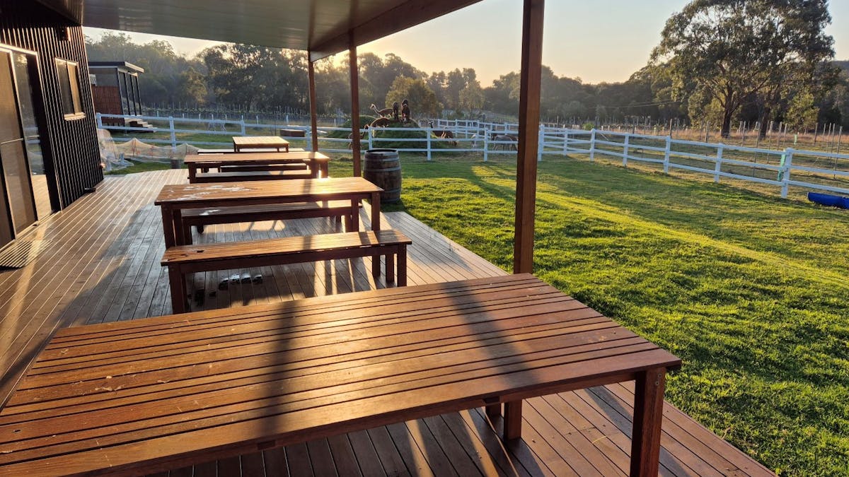 Deck of the Ginyard at sunset showing tables and grass