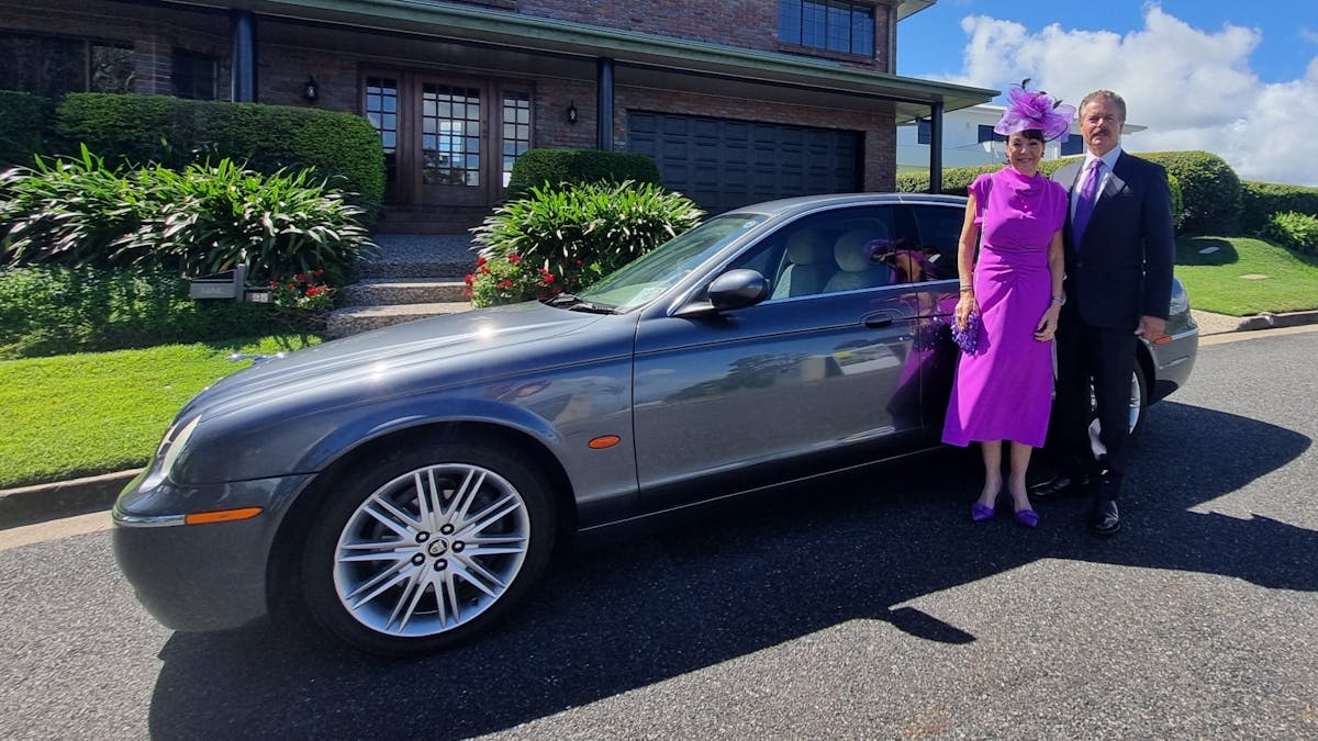 S-Type Jaguar Sedan with couple gaily dressed for The Archer Race Day in Rockhampton, Callaghan Park