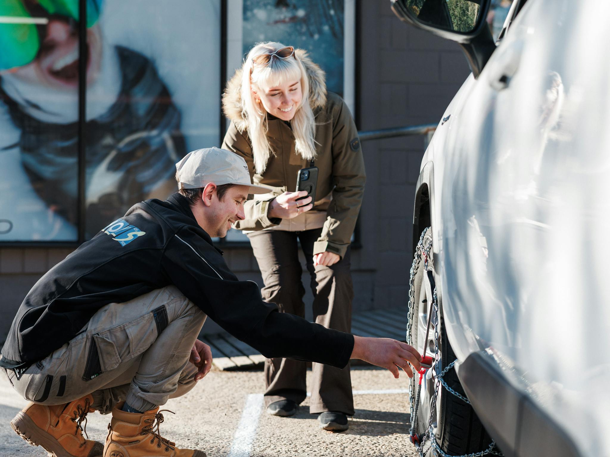 Hoys staff showing guest how to fit snow chains