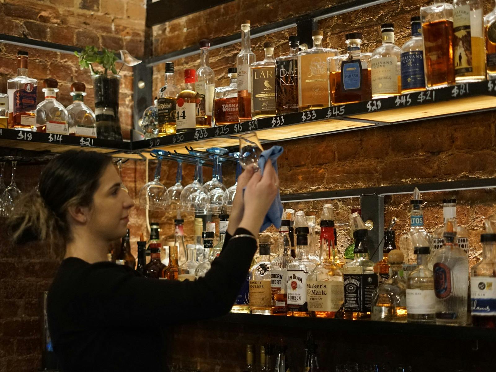 One of our staff cleaning a glass at our bar