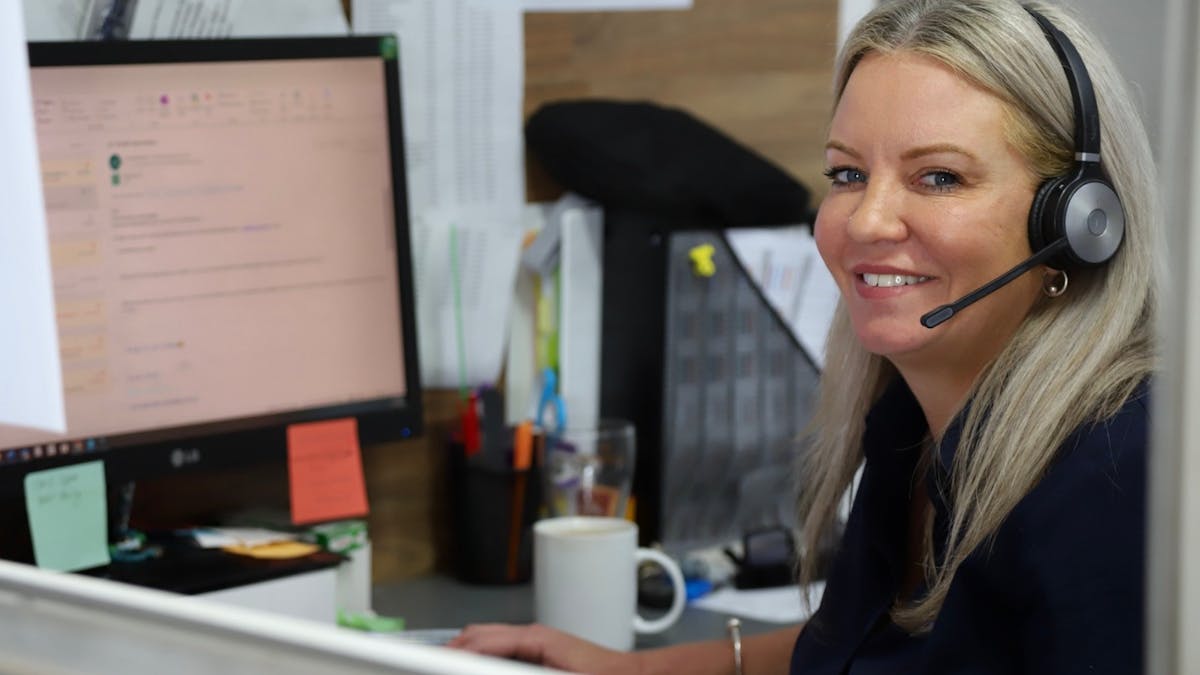 Heart of Reef Staff Member sitting at a desk and computer on the phone