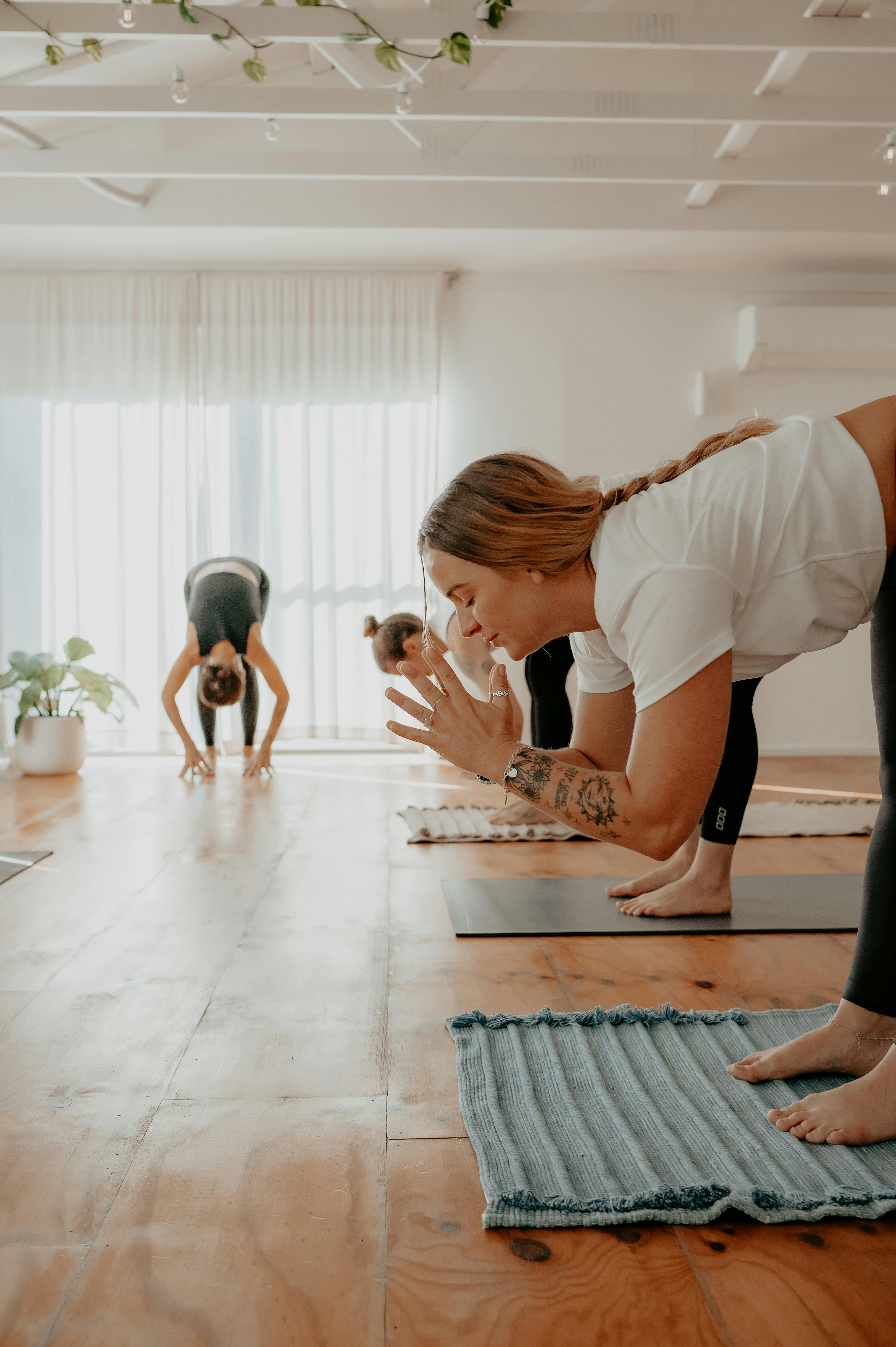 3 yoga students do yoga with yoga teacher