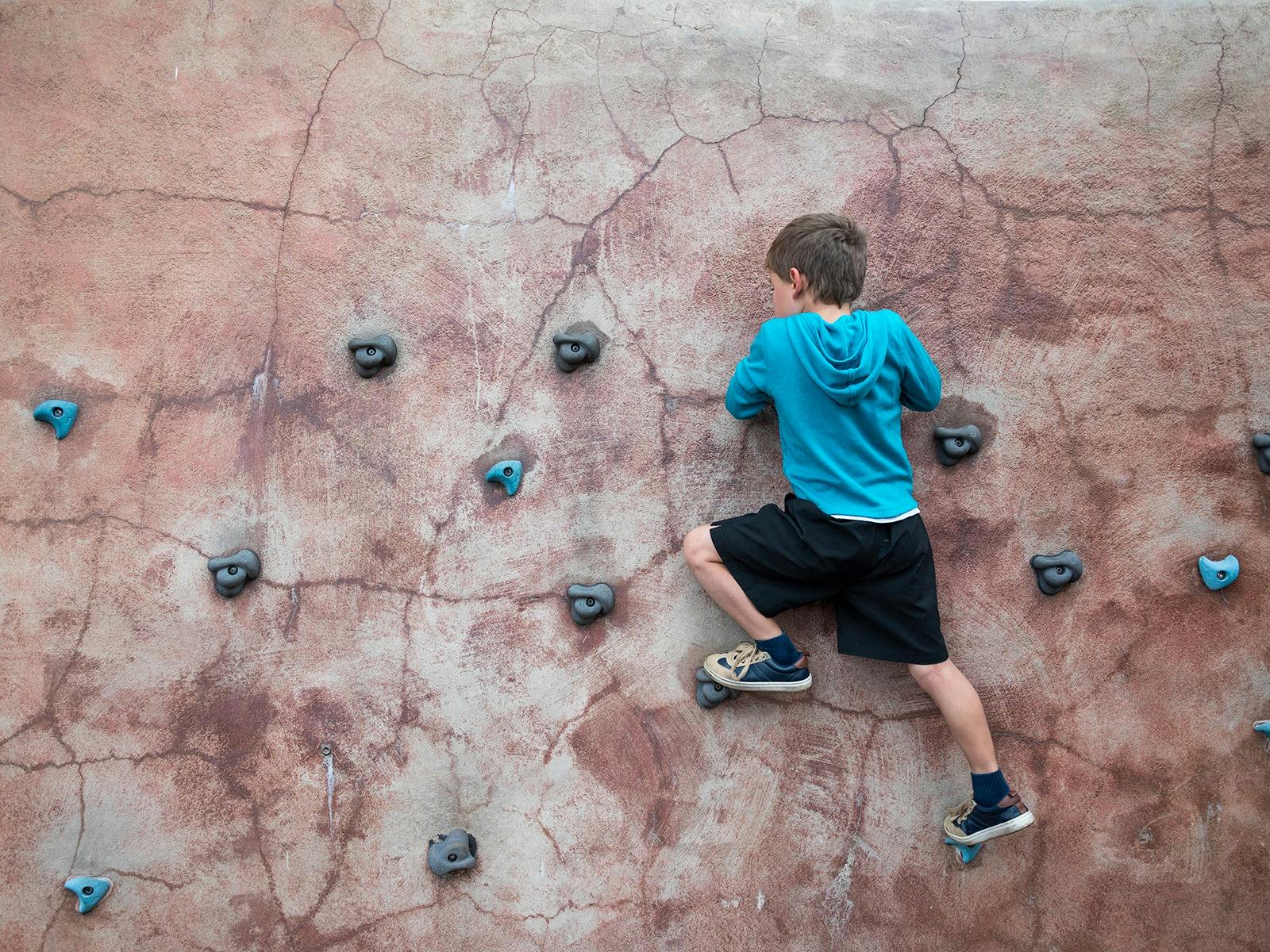 Boy climbing on bouldering wall