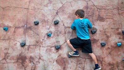 Boy climbing on bouldering wall