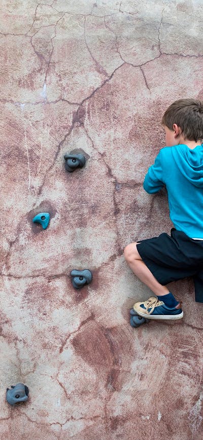 Boy climbing on bouldering wall