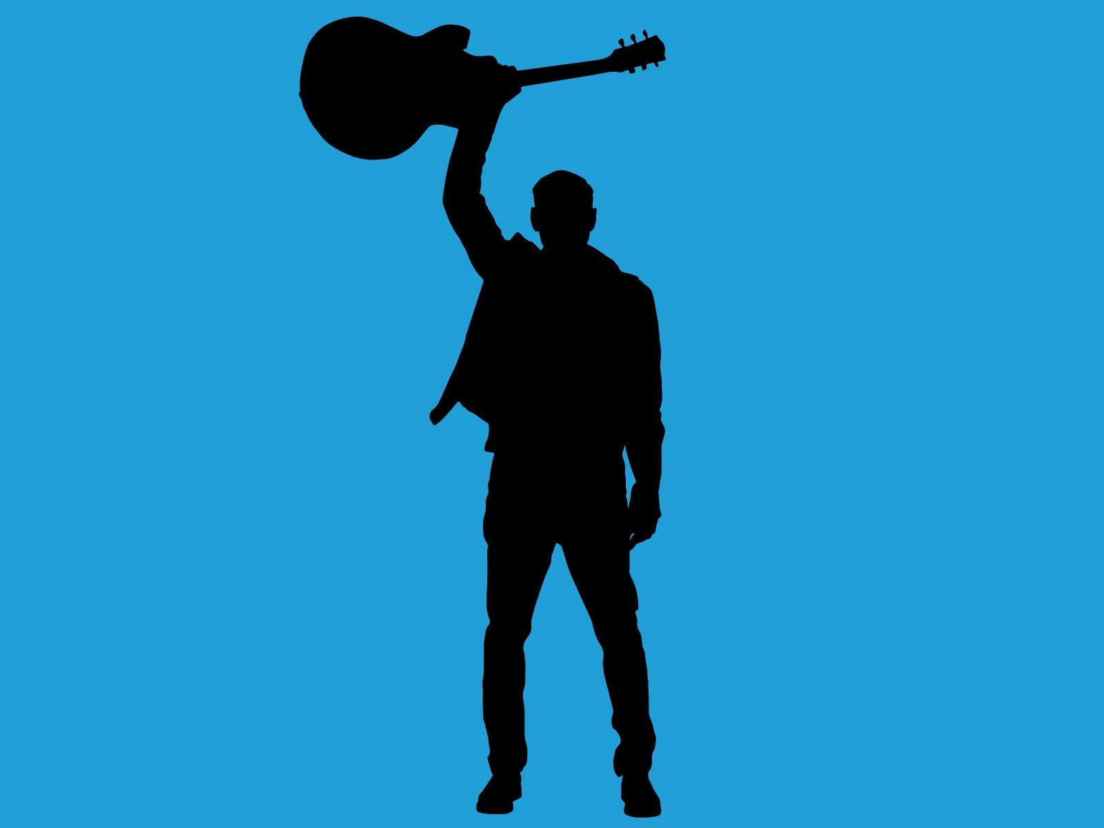 Bryan Adams holding up guitar