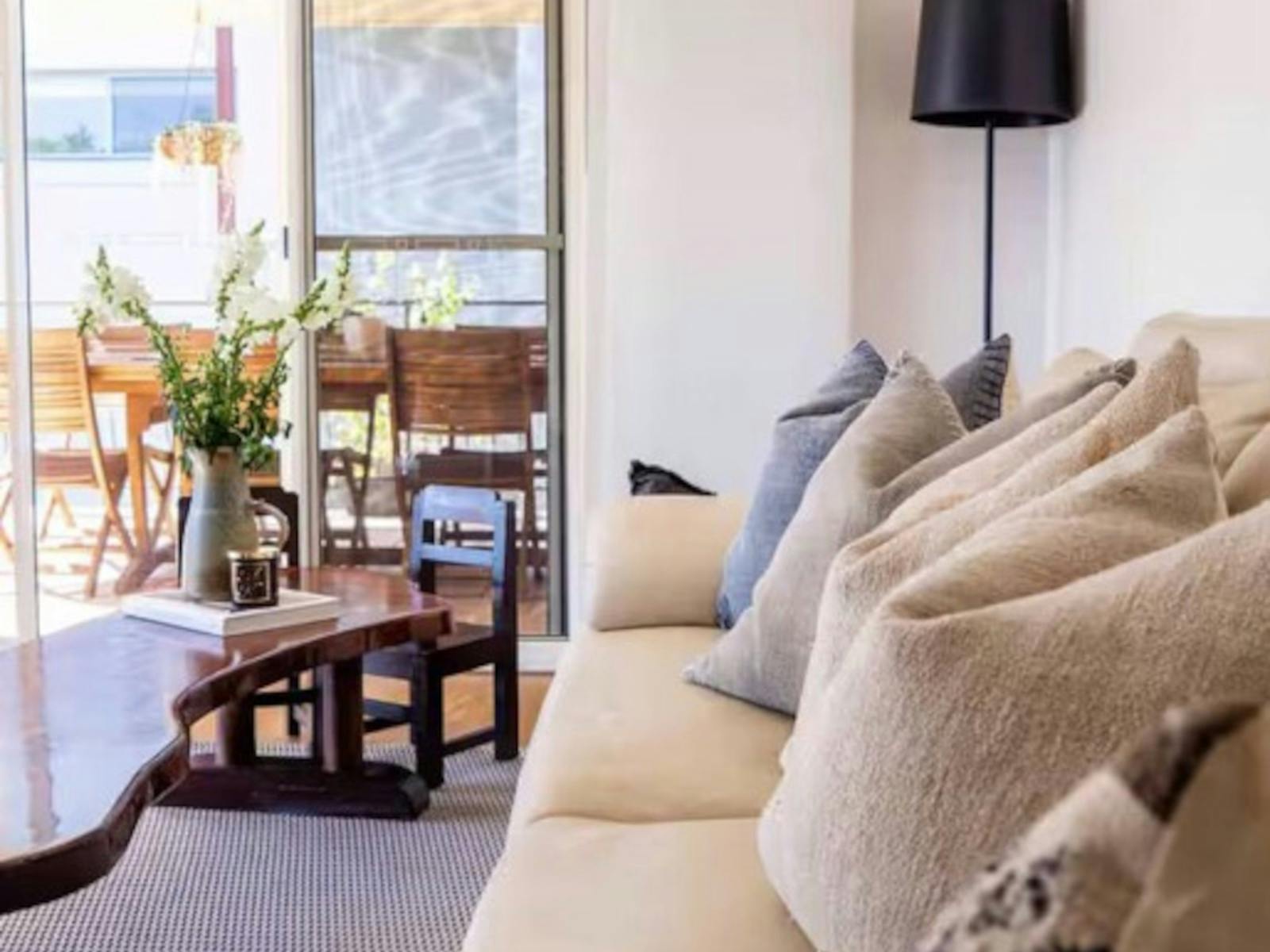 comfy lounge, timber coffee table, flowers in vase. light filled
