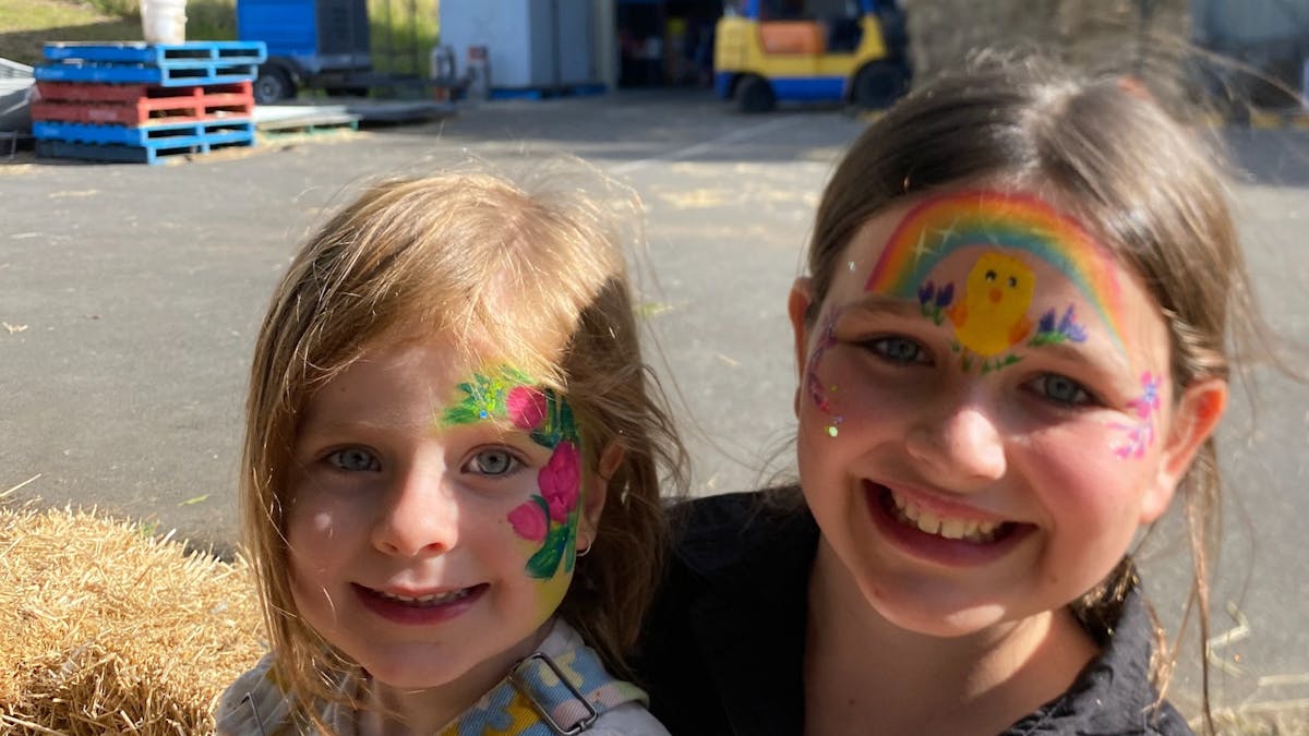 two girls smiling with their faces painted