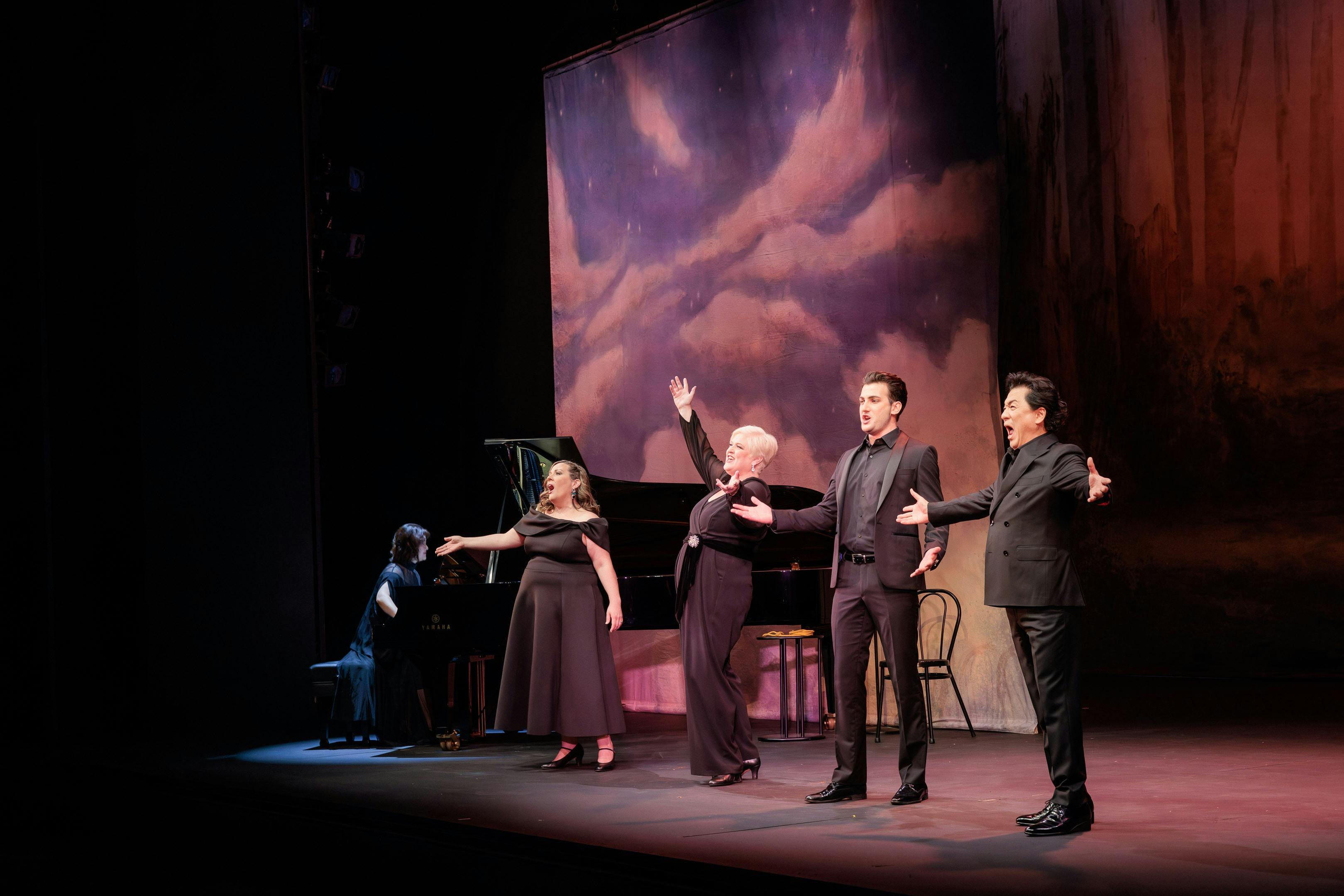 4 Opera Singers stand beside a piano singing exuberantly