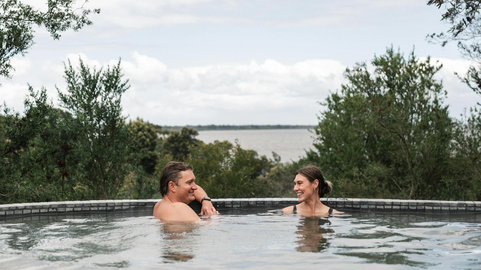 Man and woman bathing at Metung Hot Springs