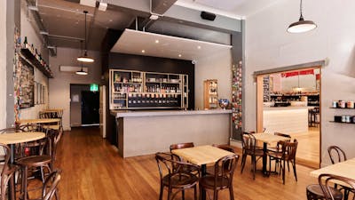 Wide view of room with bar, tables and chairs, no people
