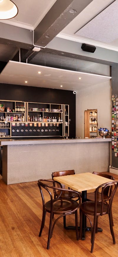 Wide view of room with bar, tables and chairs, no people