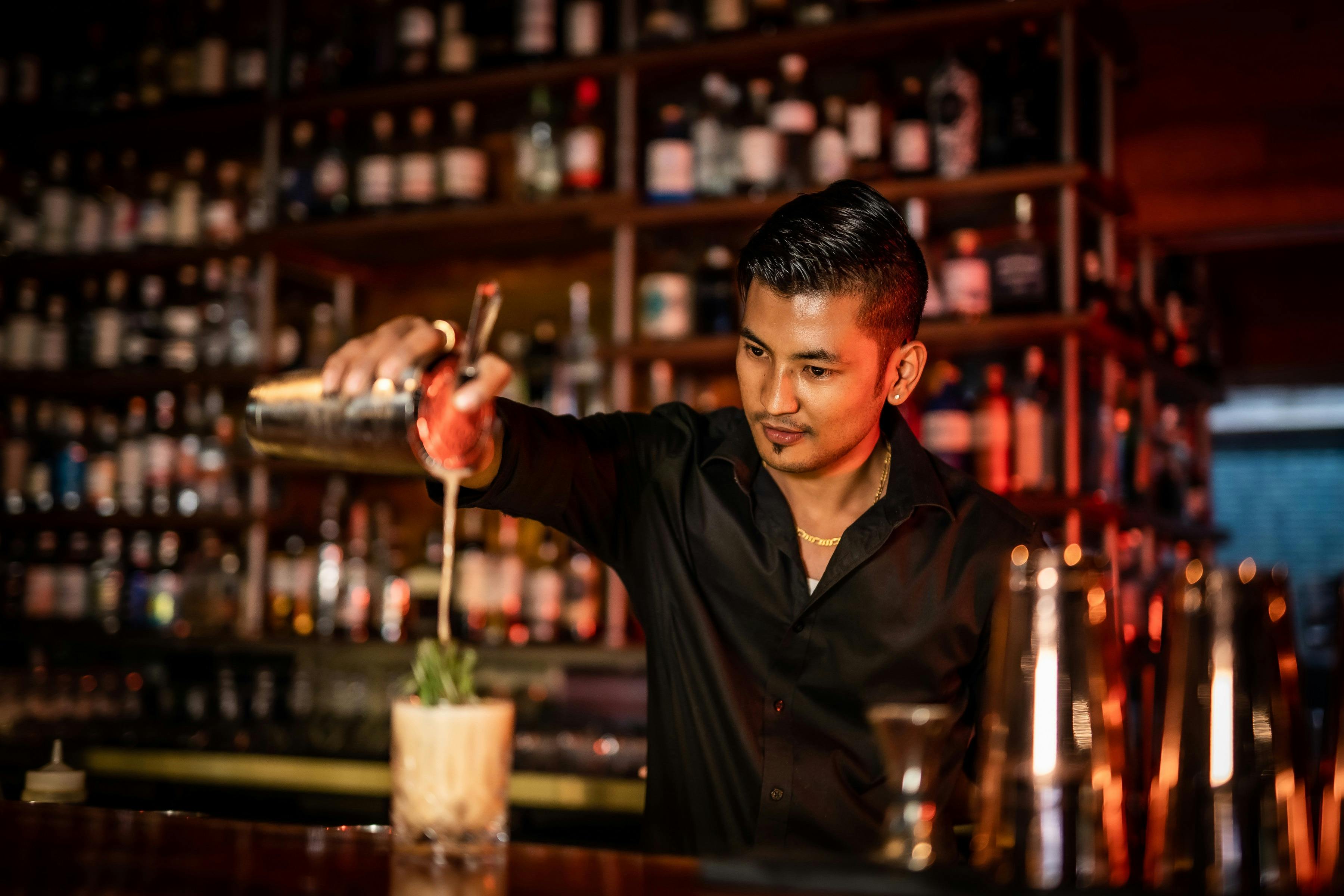A bartender pours a cocktail at the inside bar at Charlie's of Darwin