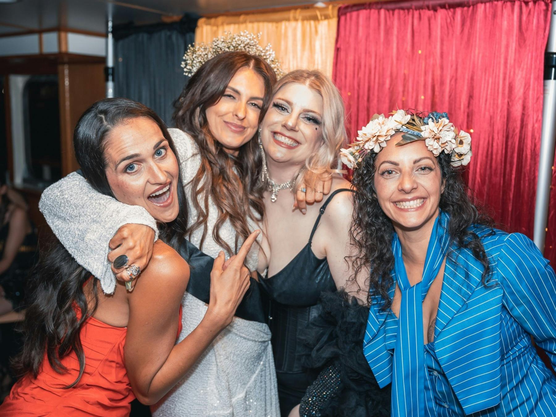 Three guests enjoying a Hens party with MC Ivana Showoff in front of the stage backdrop.