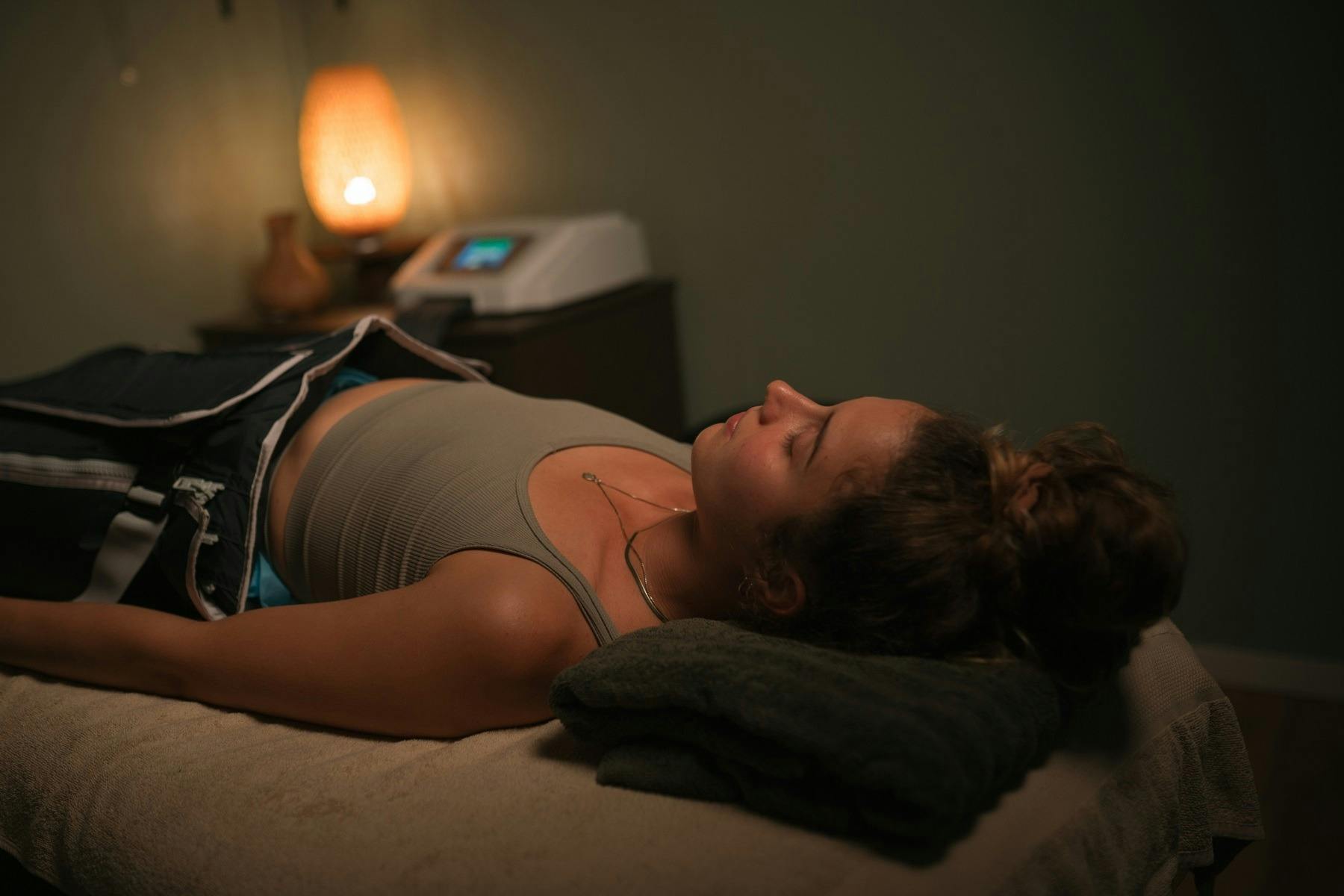 여성이 압력 치료복을 입고 누워 림프 배수 치료를 받고 있습니다.