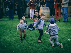 Kids dancing on the lawn, while live music is playing in background at Raidis Estate Cellar Door