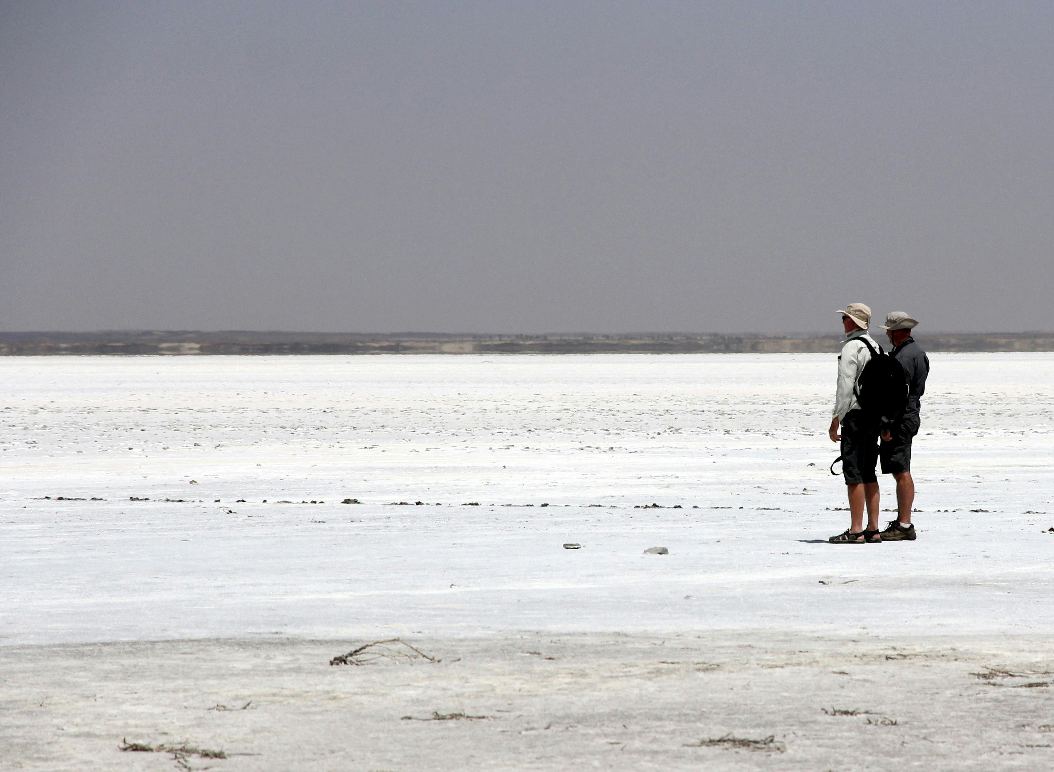 2 people standing on the white salty lake of Lake Eyre