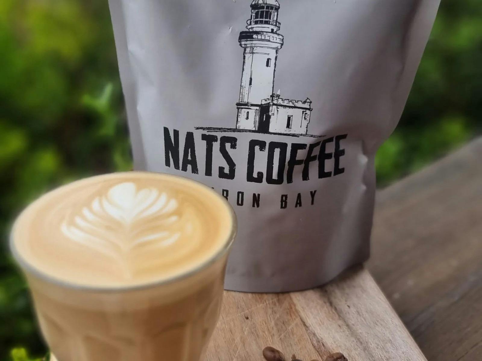 a glass of coffee with a bag of beans