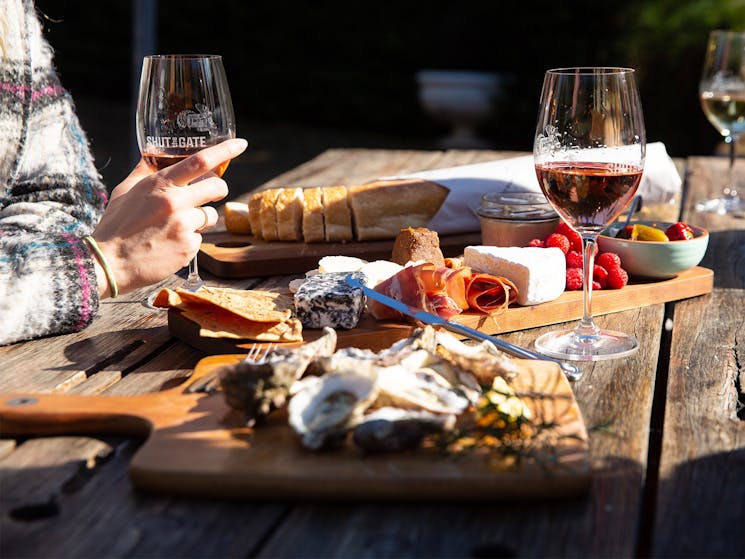 Selection of cheeses on board with wine glasses