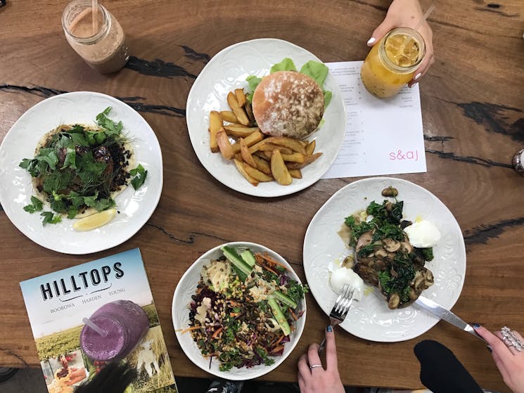 Overhead shot of table with four dishes and Hilltops Destination Guide