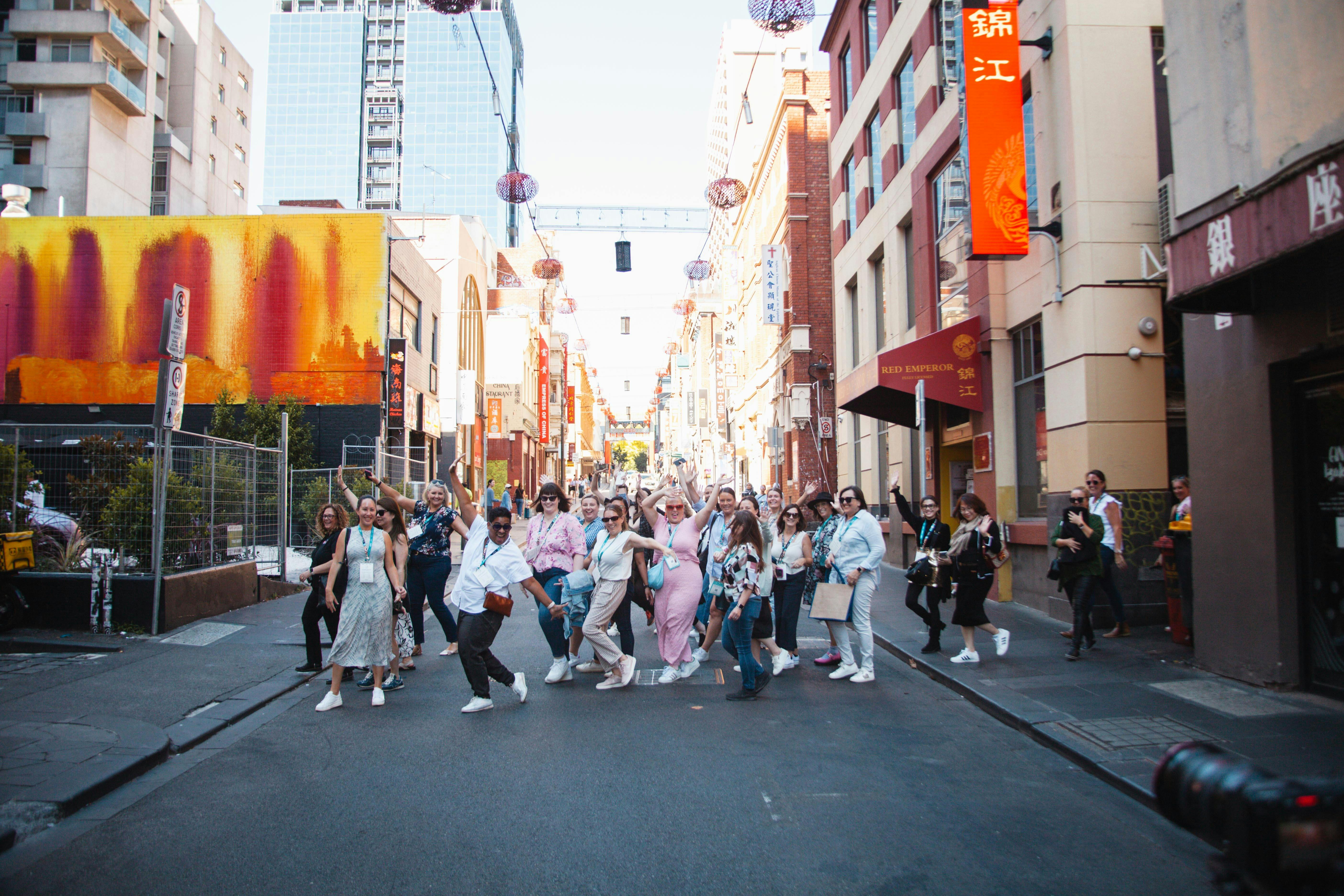 A tour group are crossing the road in Chinatown.