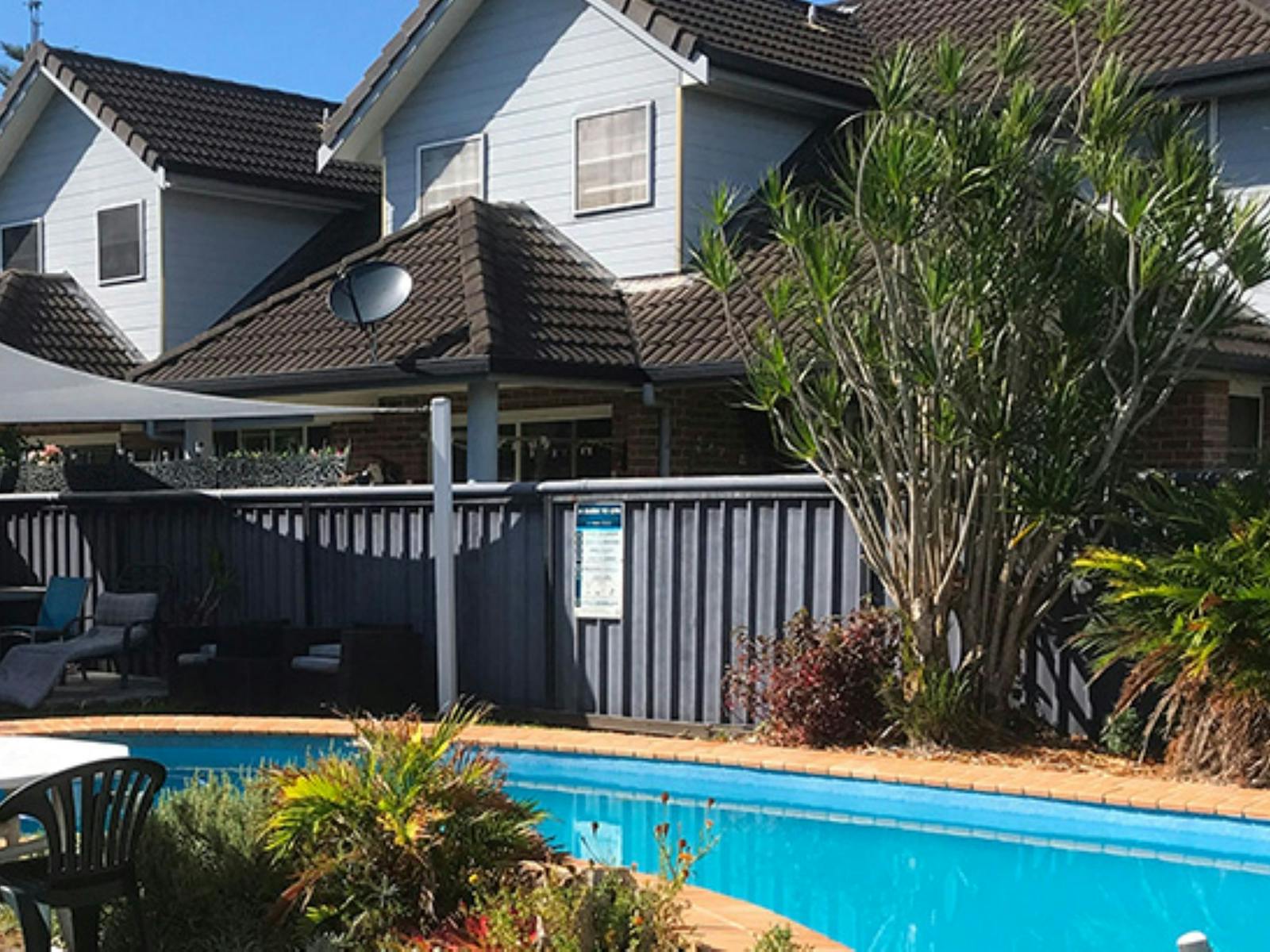 Image of an outside pool bordered by a fence and houses
