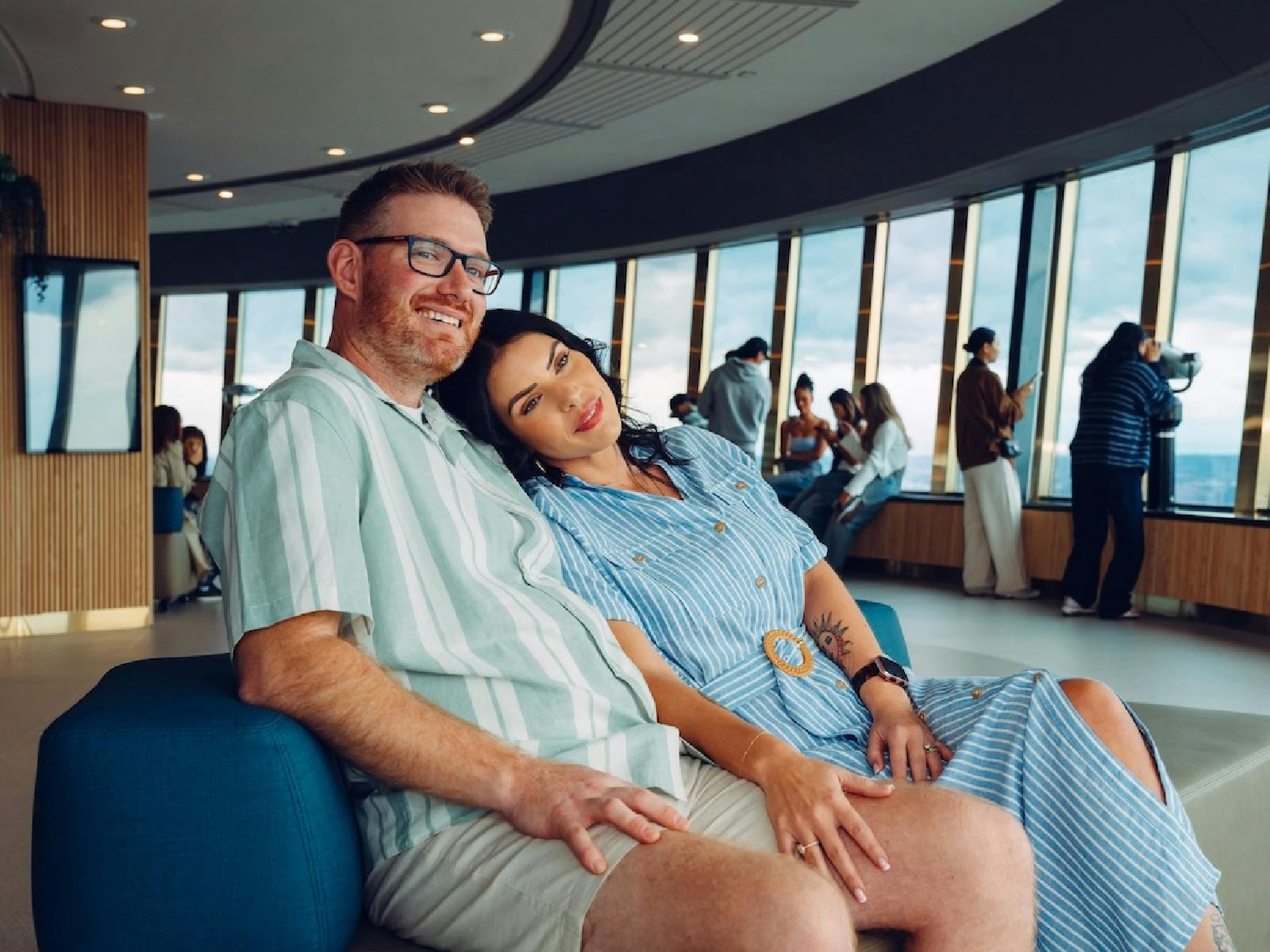 Parents resting on the sofa and enjoying the view on the reimagined observation deck
