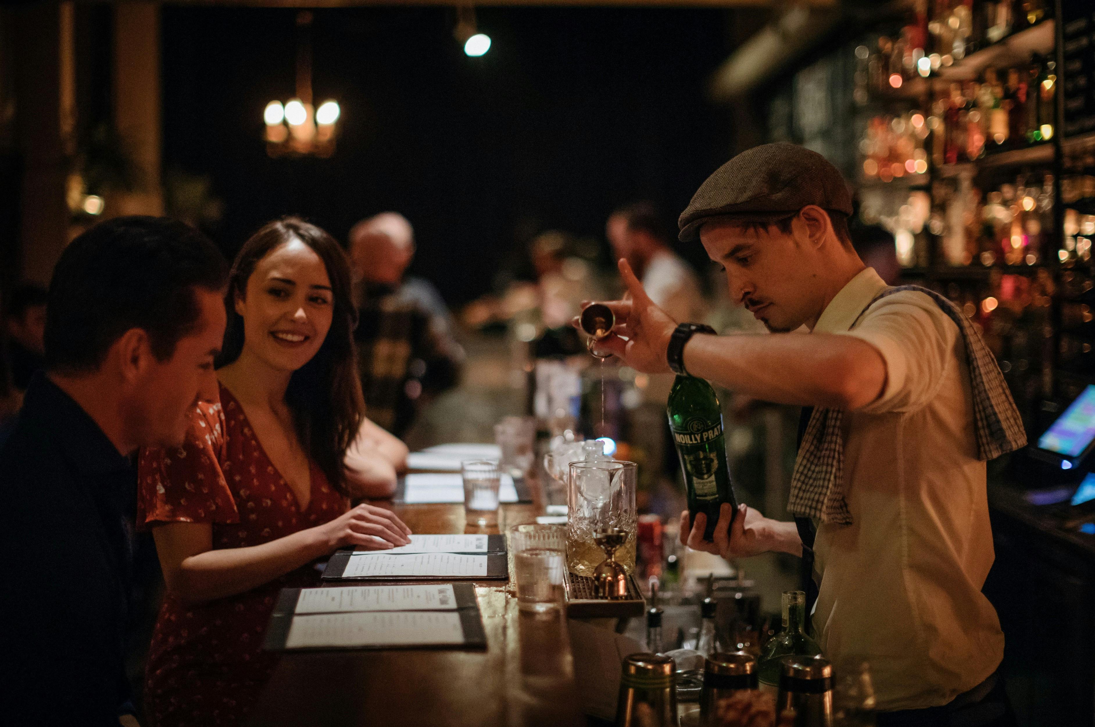 Bartender pouring cocktails for patrons at retro-chic bar Coal & Cedar in Newcastle