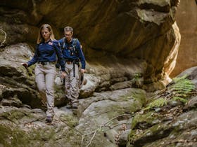 Two tour guides walk through a narrow side gorge at Carnarvon Gorge.