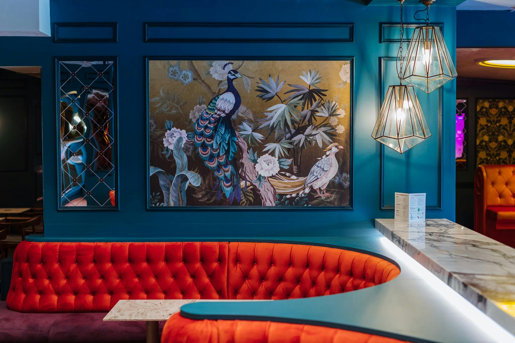 벽에 고급스러운 빨간색 바 부스와 파란색 공작 작품