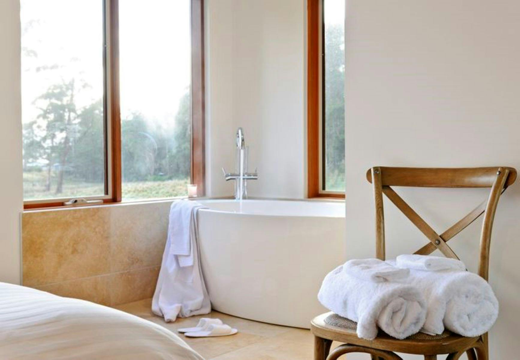 The master bedroom free standing bath, takes in views across the property with forest and wallabies