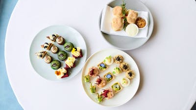 Birds eye view of three high tea plates featuing scones, cakes and small goods
