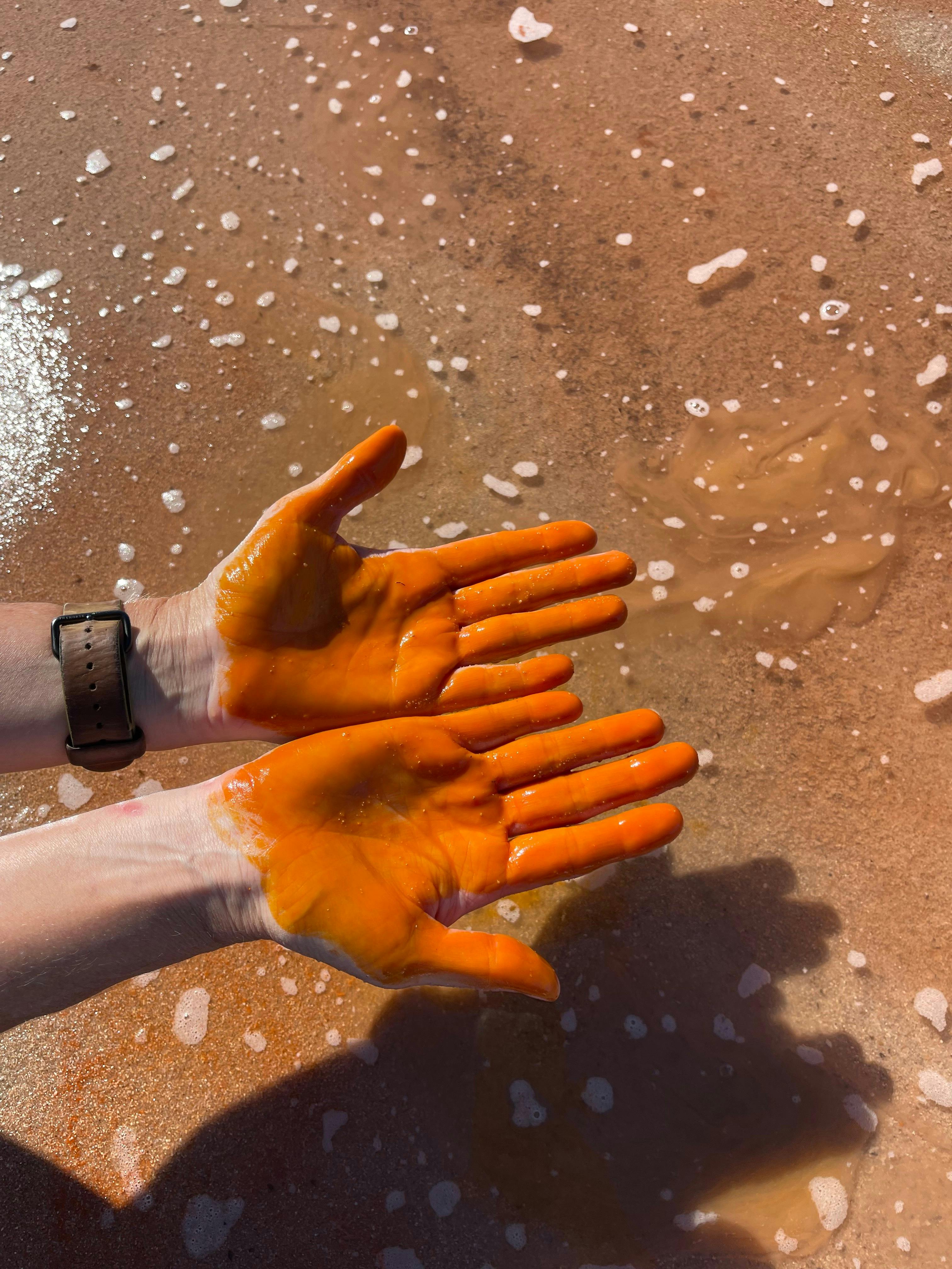 Orange hands from the Pink Lake algae