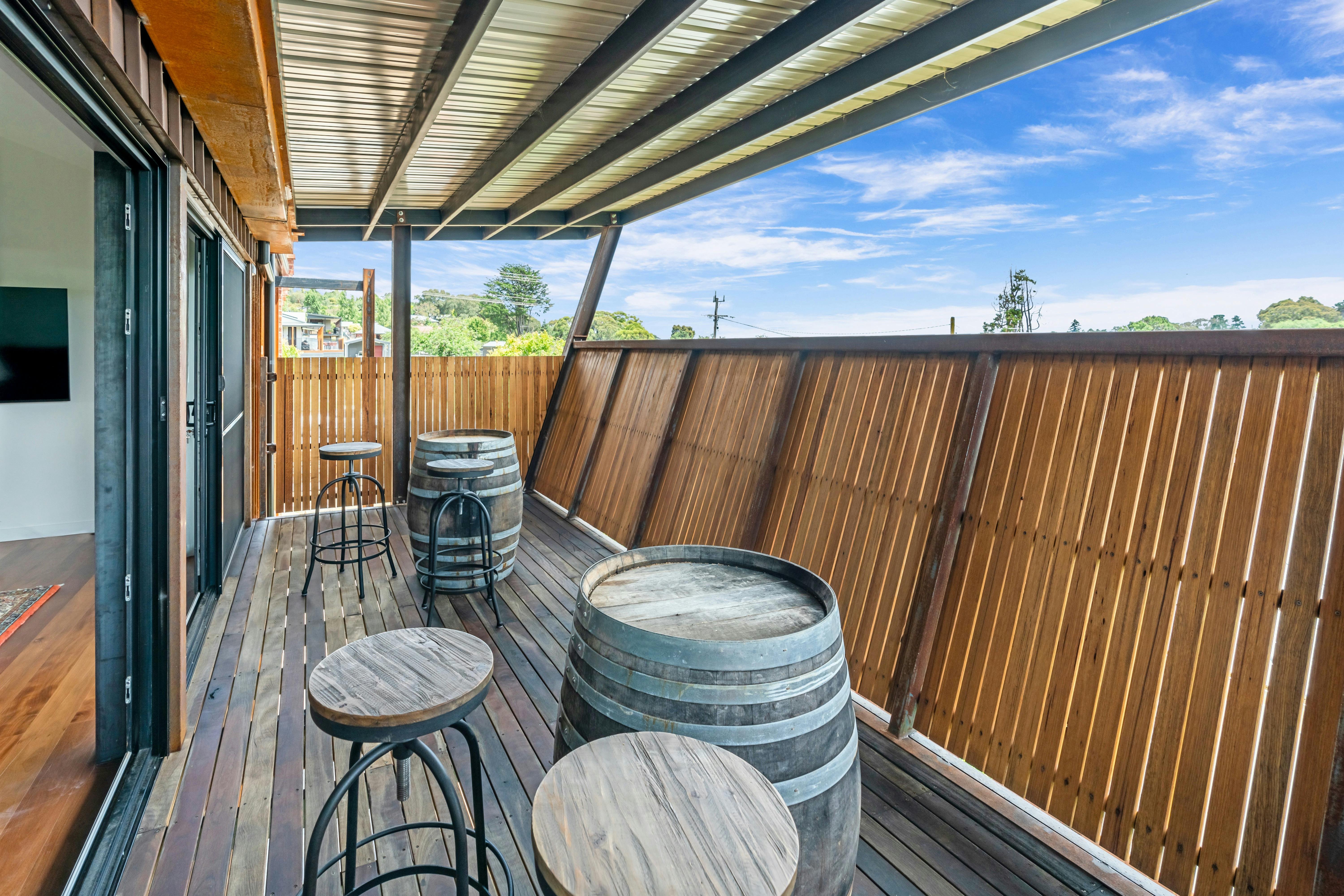 Upstairs balcony with local wine barrels and stools with a view over picturesque Beechworth