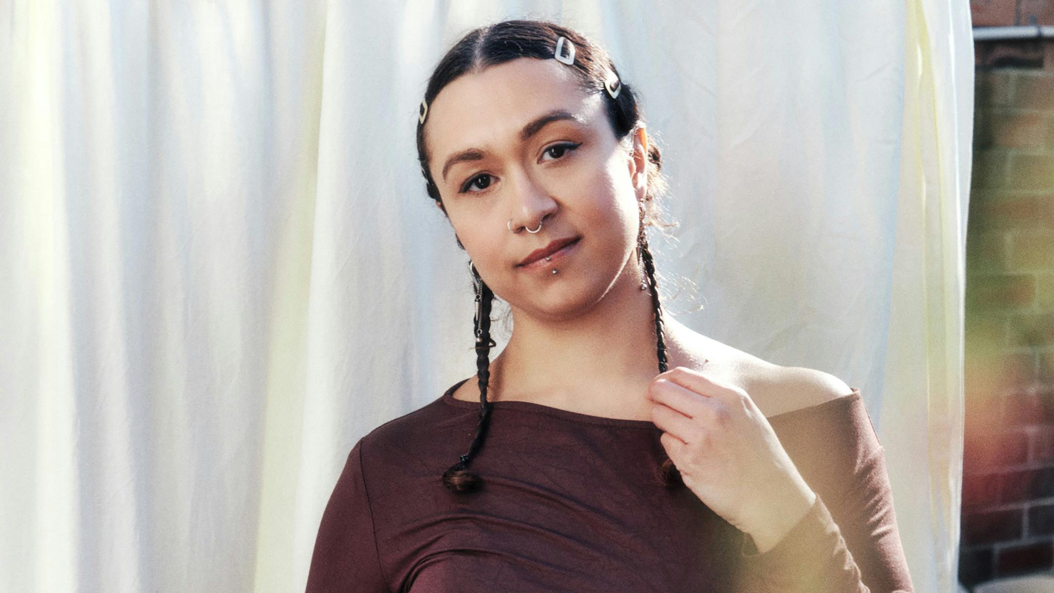 A woman with braids in front of a white sheet