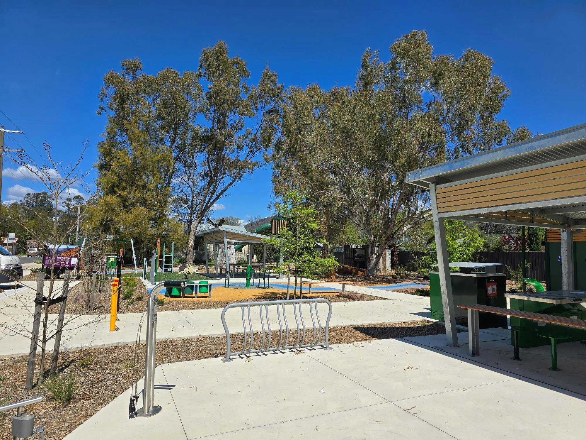 Bicycle repair station on concreted area with trees and blue sky in background