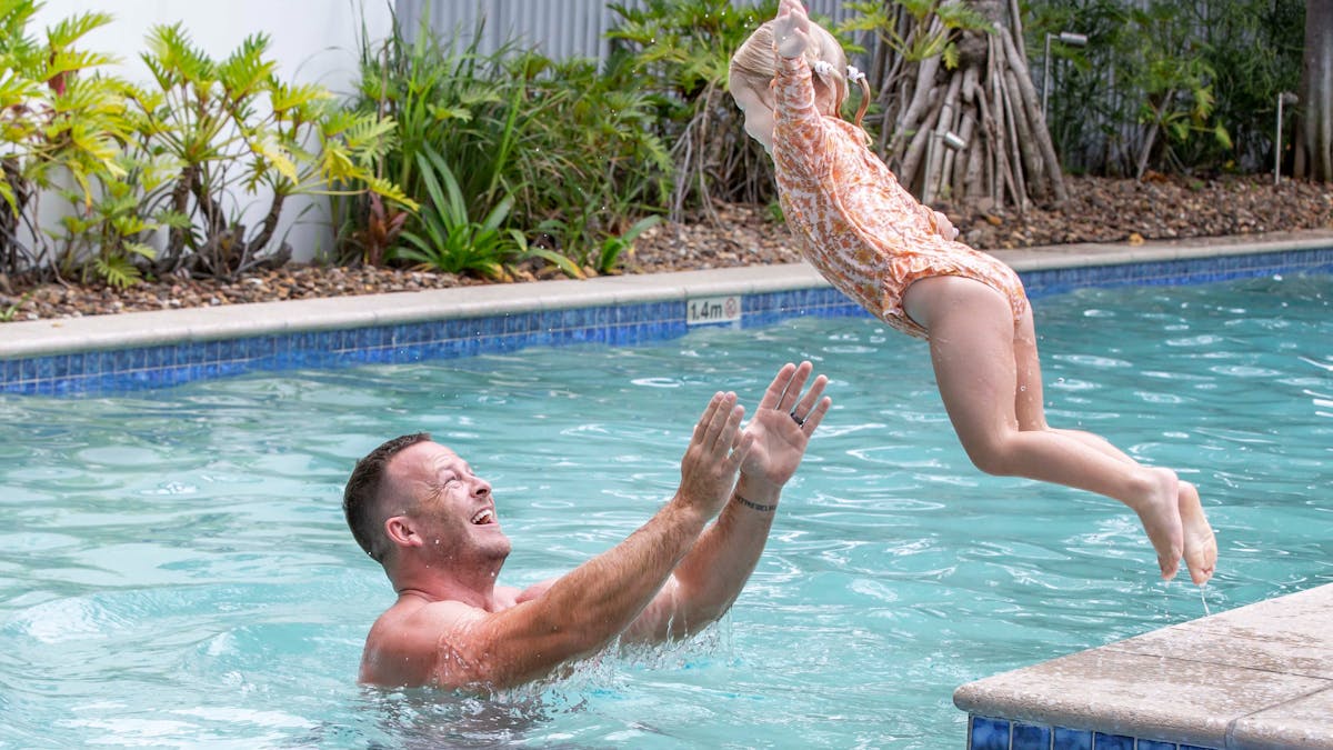 Kid jumping to their Dad in the pool