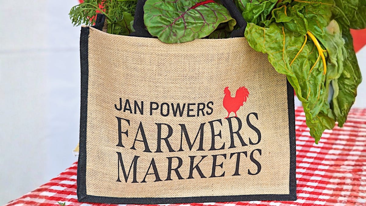 A JPFM hessian market bag overflowing with fresh produce