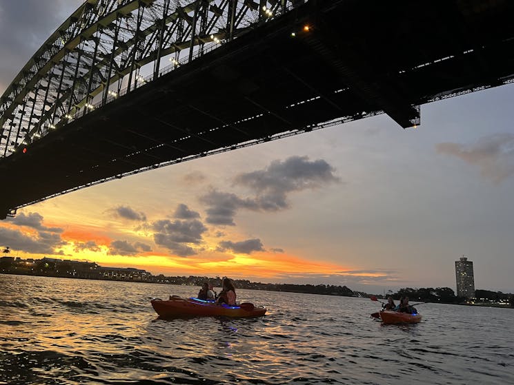kayakers under the Harbour Bridge with the last rays of dusk
