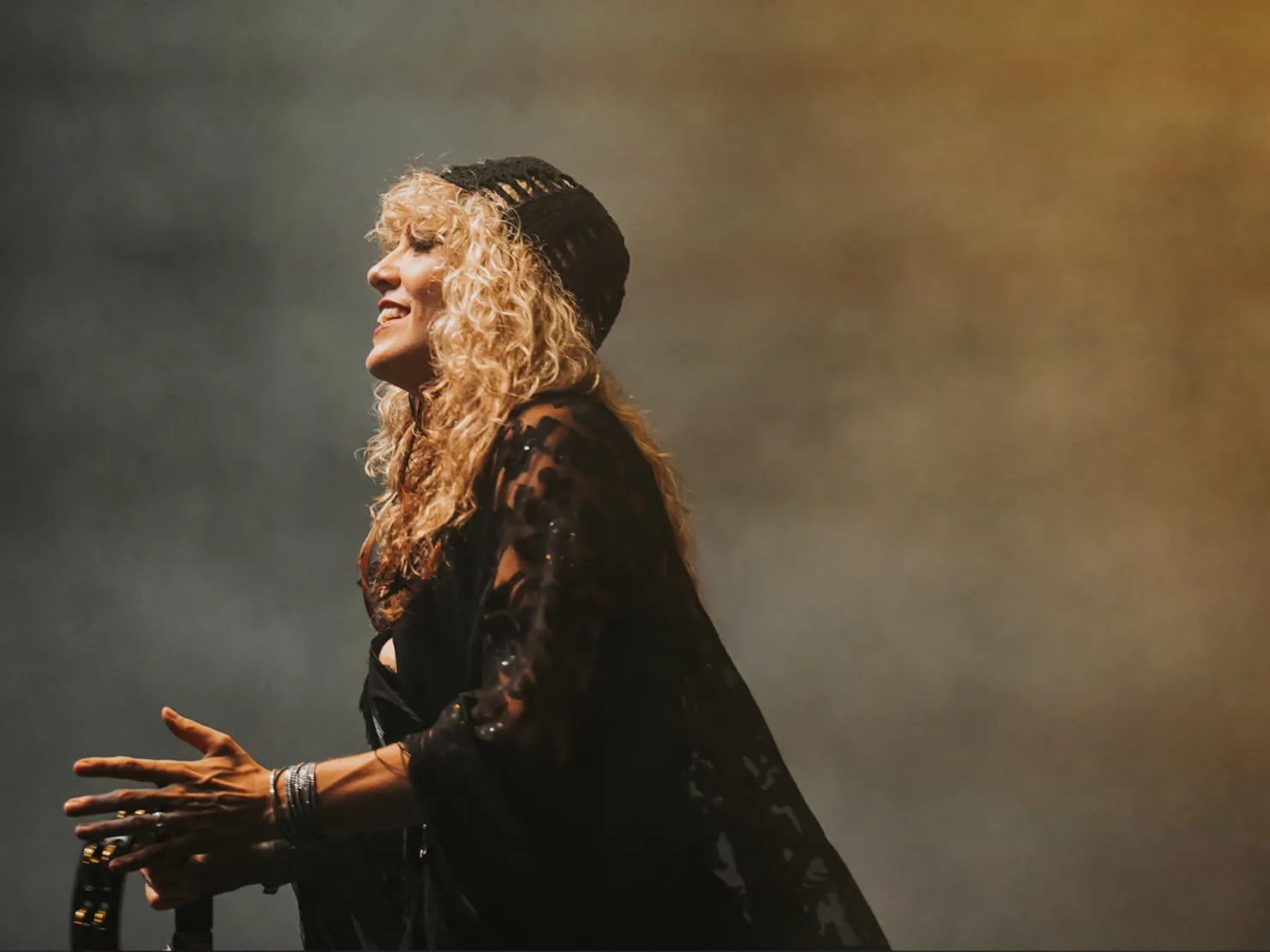 Woman on stage dressed as Stevie Nicks peforming