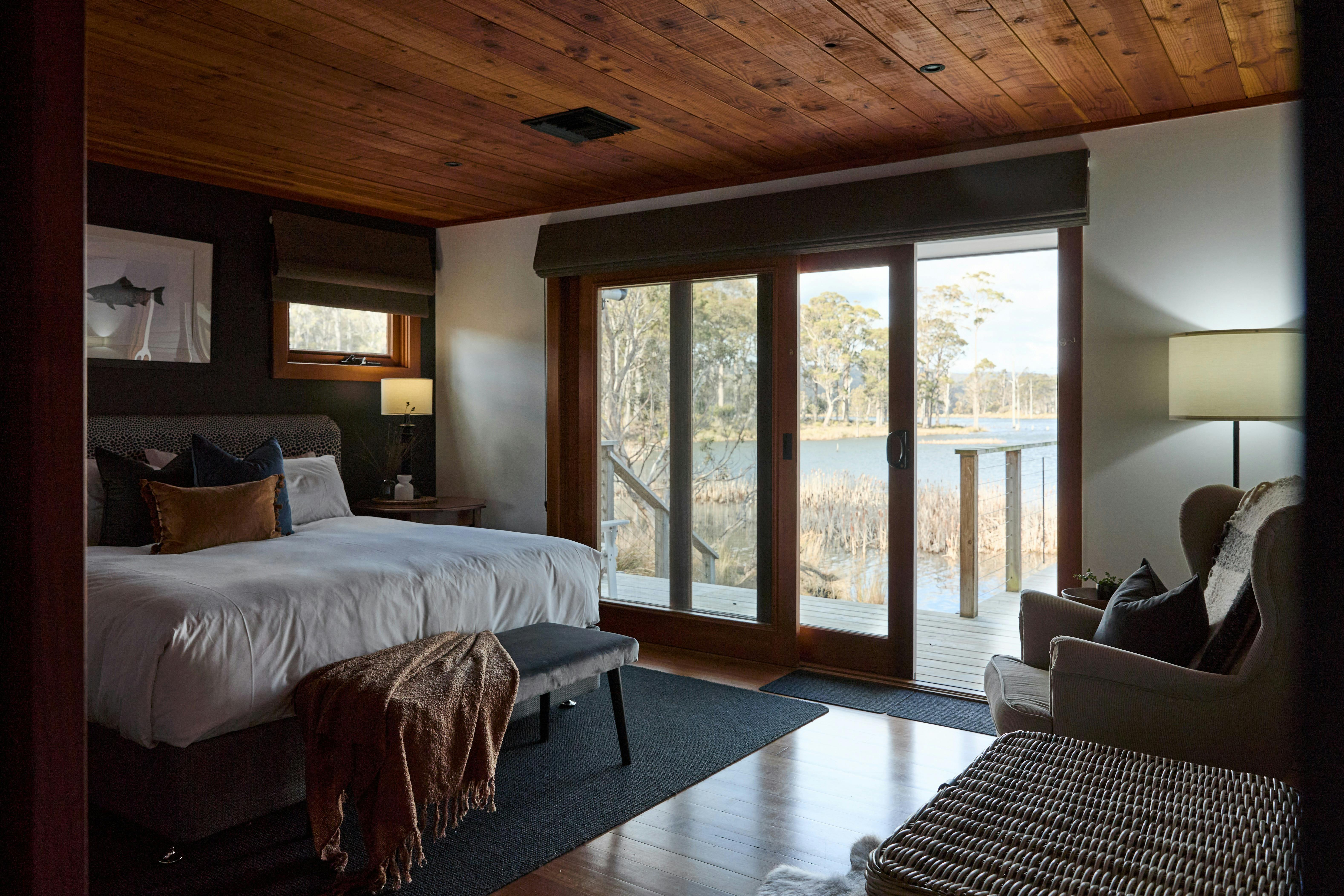 Master bedroom with large glass door onto deck overlooking the bush and a lake