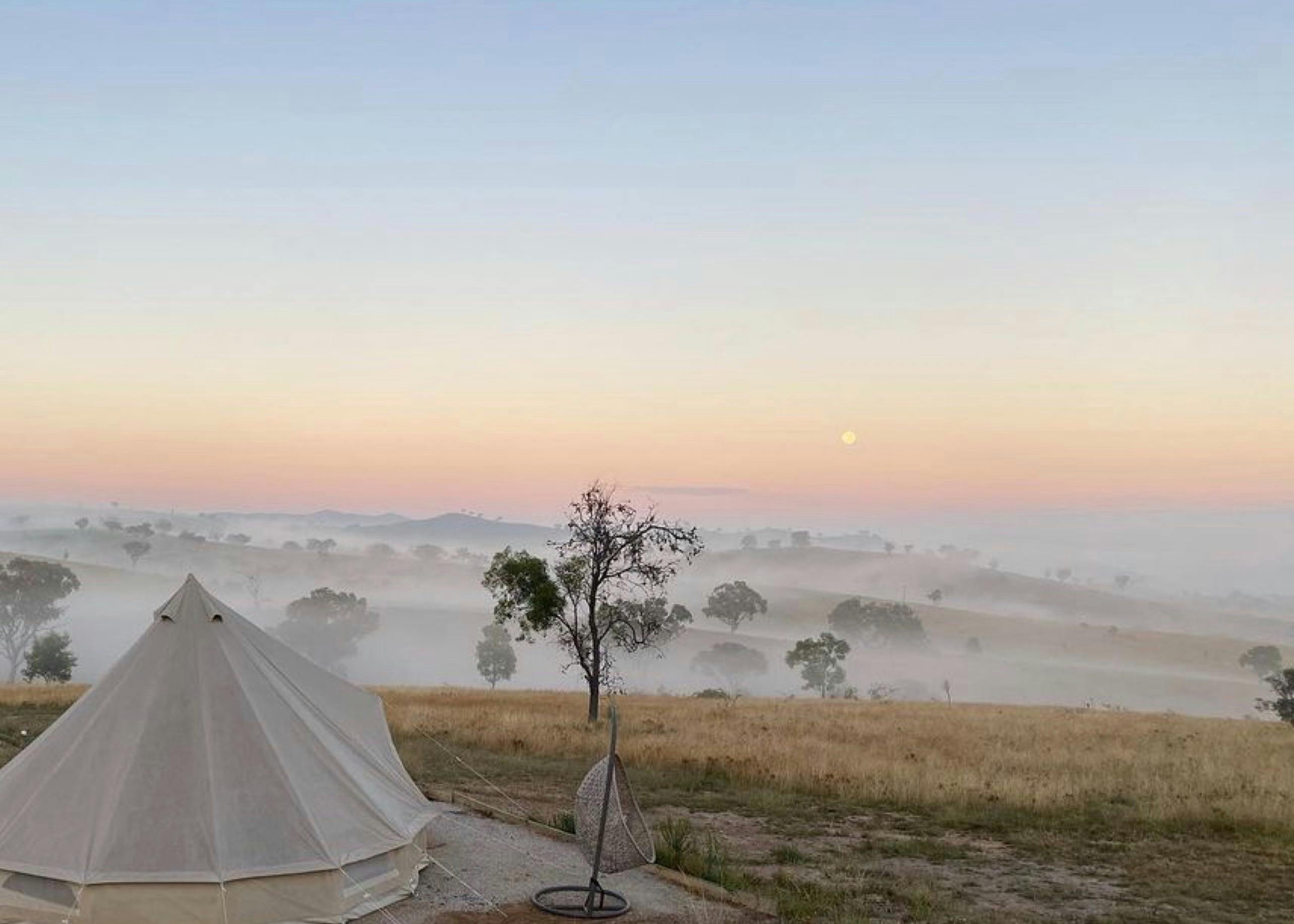 Luxury glamping tent overlooking misty countryside at sunrise at Glenayr Farm, Mudgee