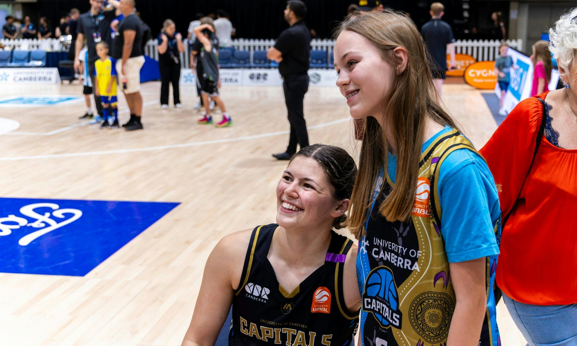 UC Capitals player posing with fan after a game.