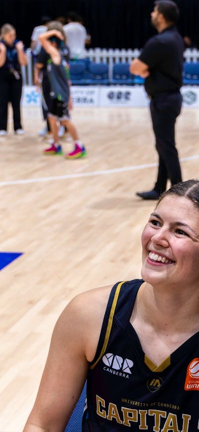 UC Capitals player posing with fan after a game.