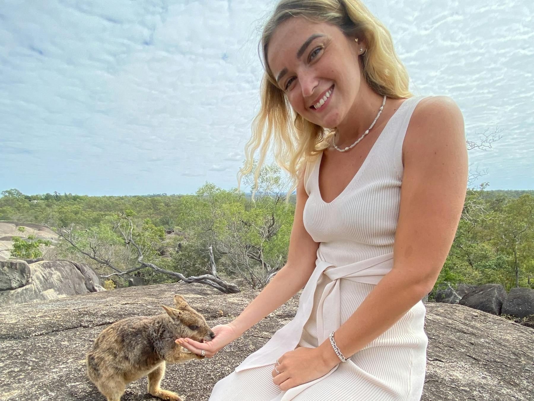 Girl enjoys the experience of hand feeding the unadorned rock wallaby at Granite Gorge
